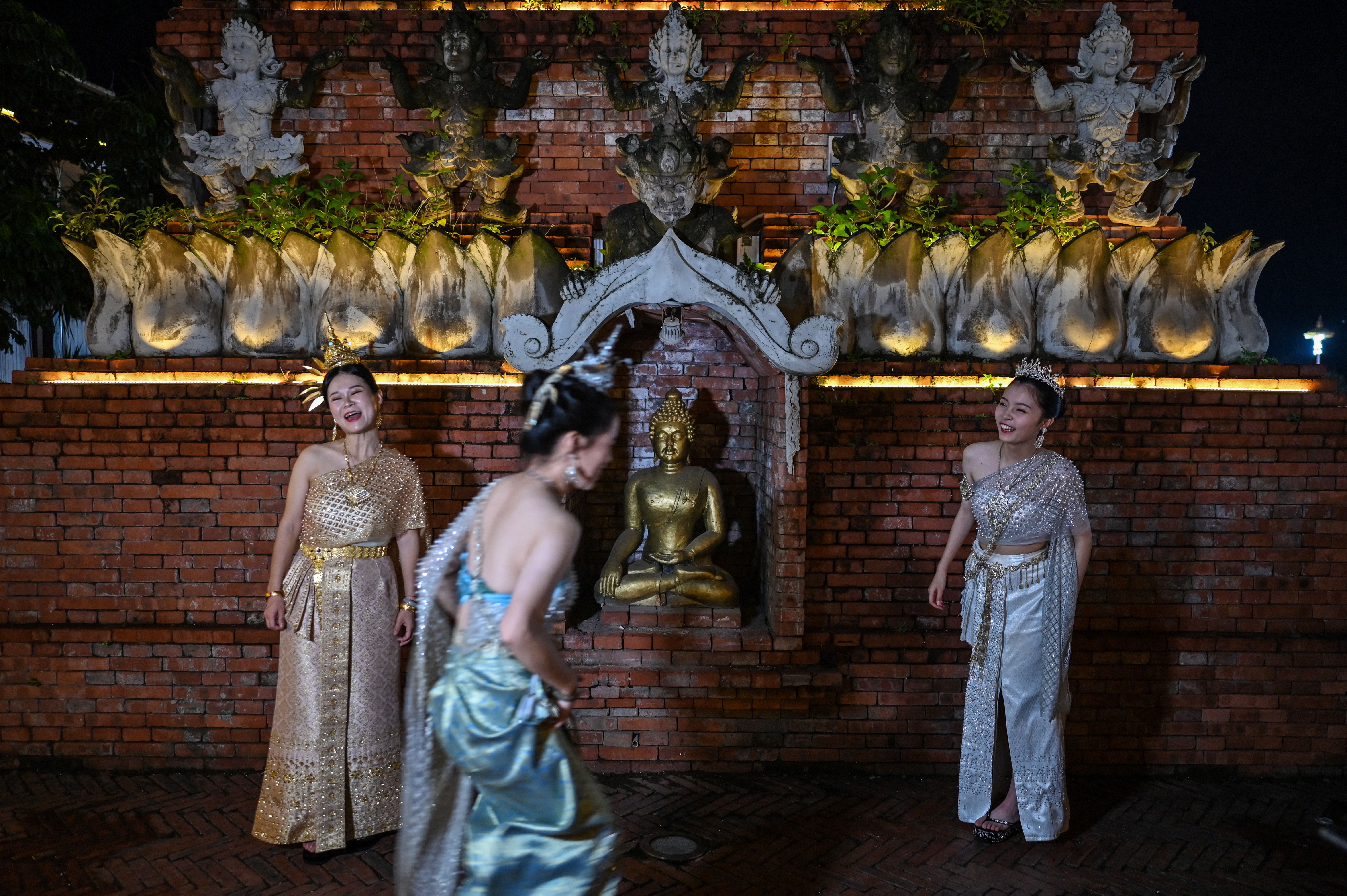 นักท่องเที่ยวแต่งกายคล้ายชุดไทยในสิบสองปันนาของจีน (ภาพจาก: Hector Retamal/AFP)