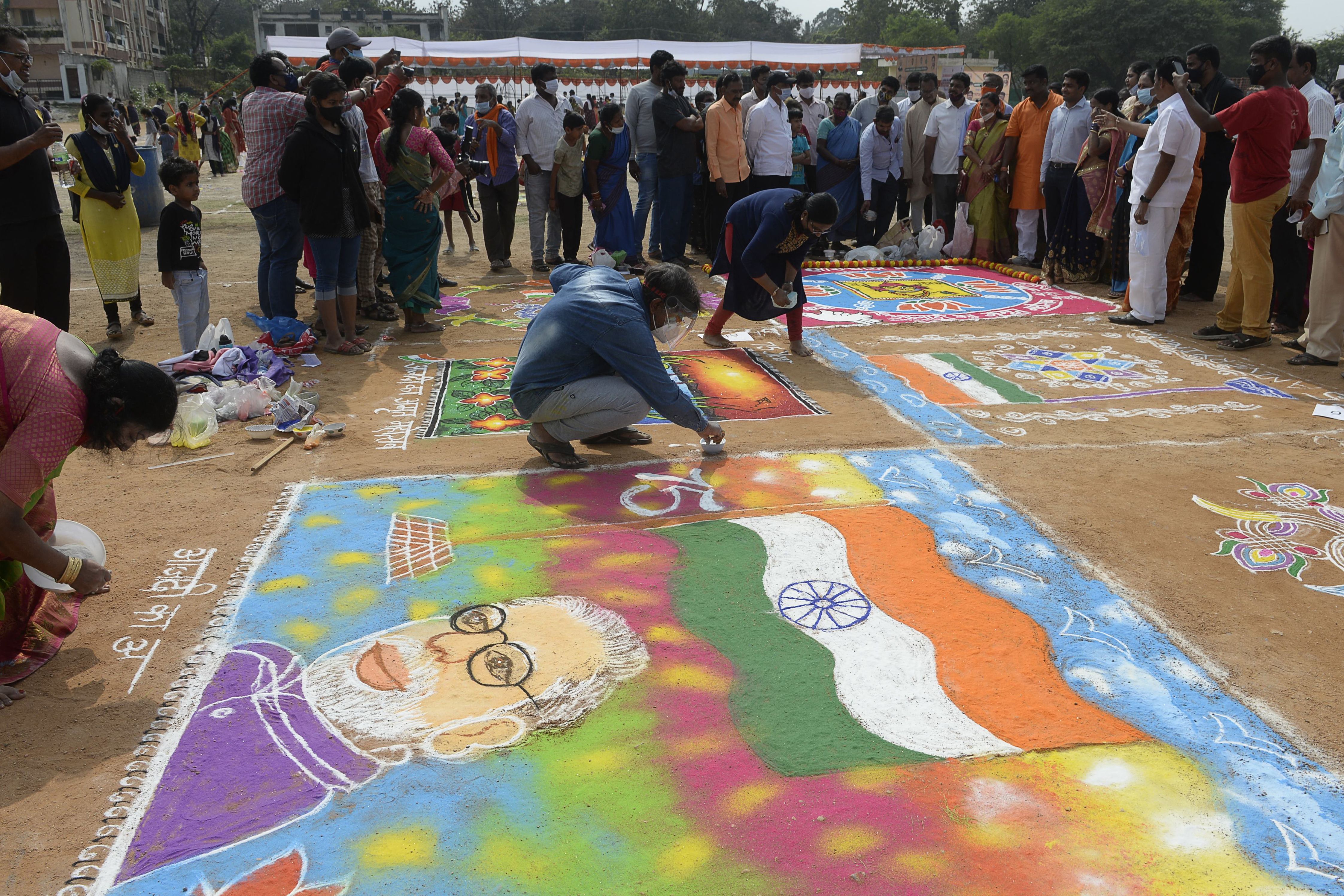 การระบายสีลงบนพื้นถนนในอินเดีย เพื่อเฉลิมฉลองสังกรานติ (Photo by NOAH SEELAM_AFP)