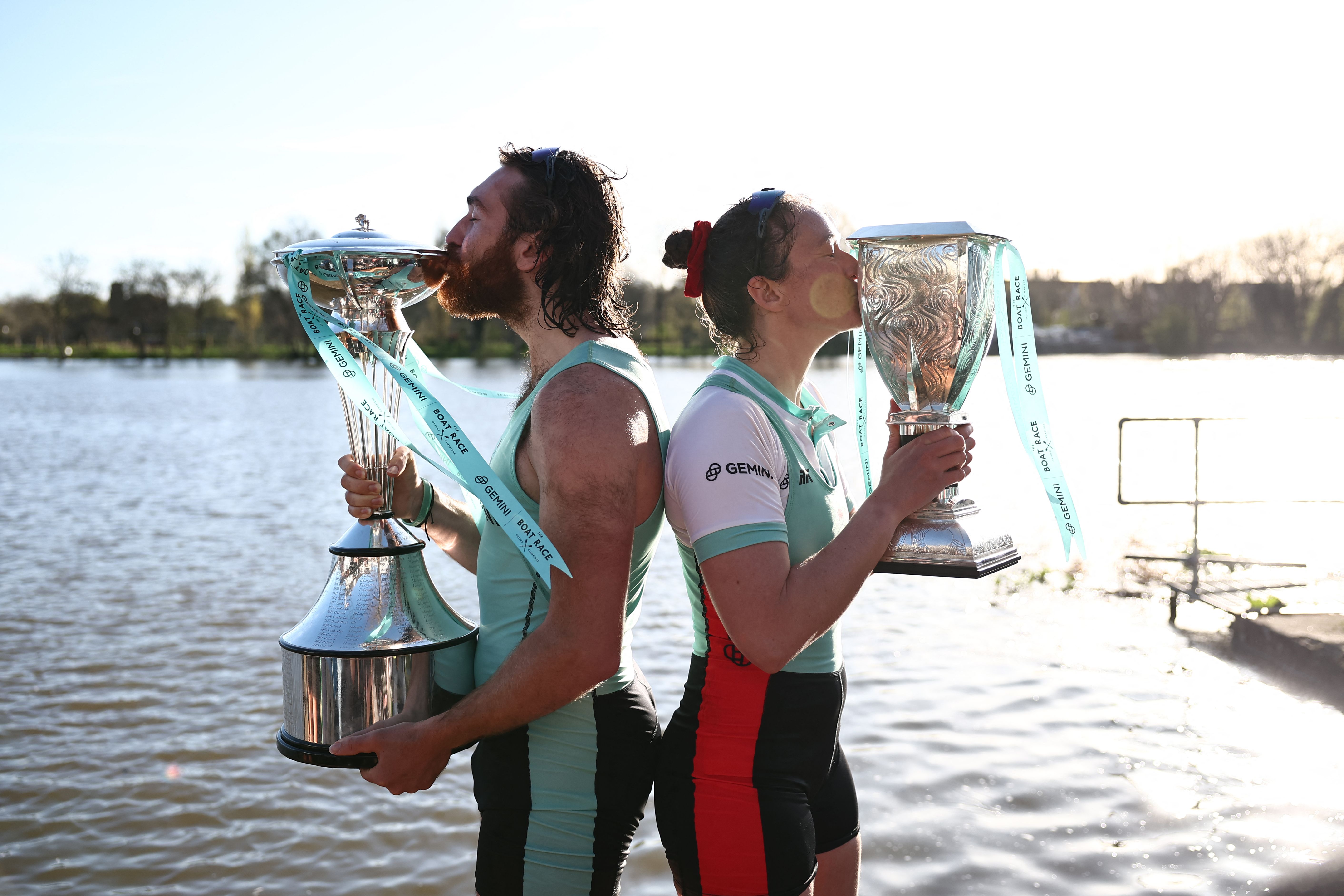ประธานฝั่งชายและหญิงทีมเรือพายของเคมบริดจ์กำลังถือถ้วยรางวัล จาก The Boat Race เมื่อปี 2024 (ภาพจาก: Henry Nicholls/AFP)