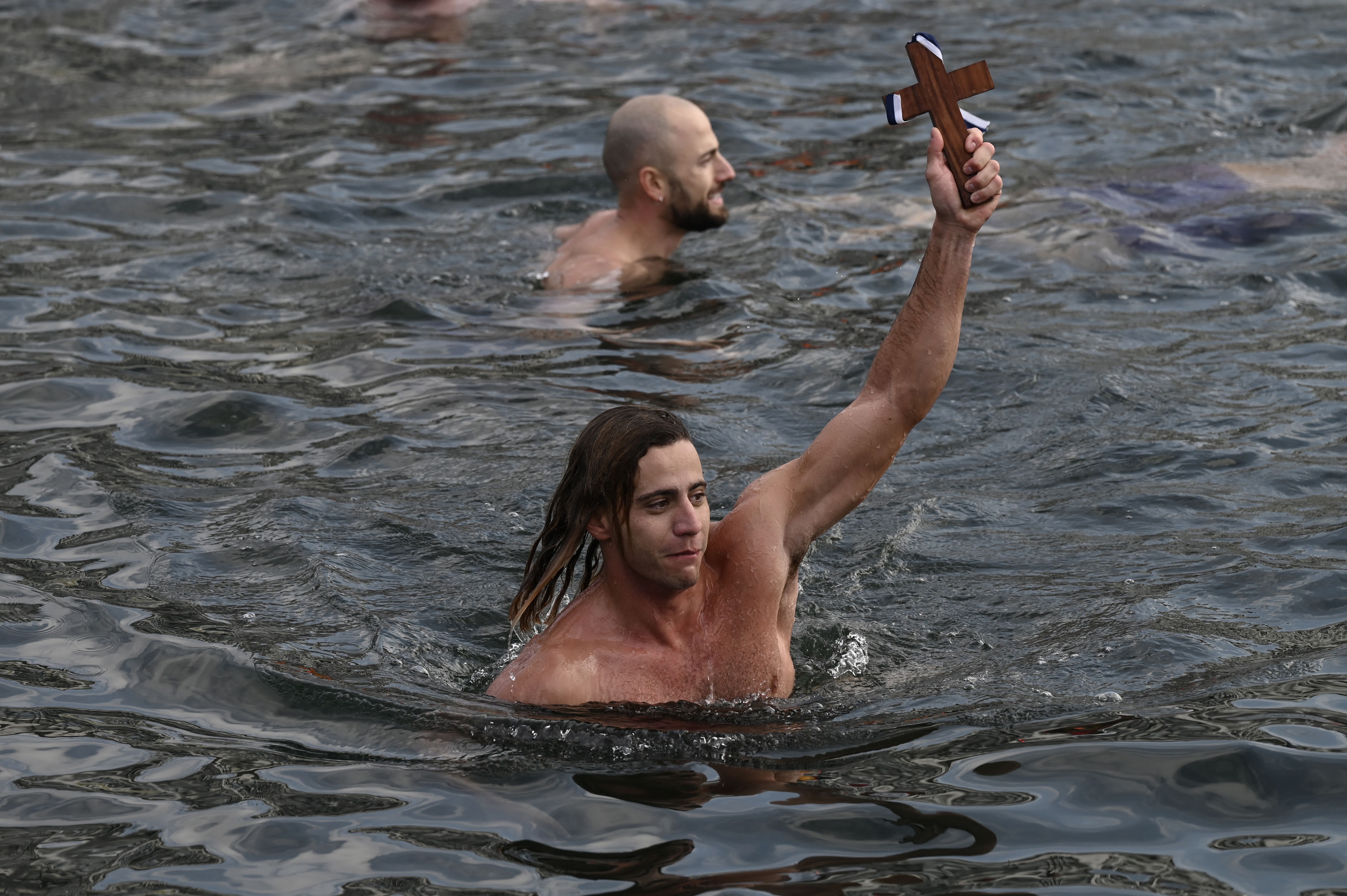 ชาวคริสต์นิกายออร์ทอดอกซ์คนหนึ่งในกรีซ งมไม้กางเขนขึ้นมาจากทะเลได้ในวัน Epiphany เมื่อปี 2025 (ภาพ: Sakis Mitrolidis/AFP)