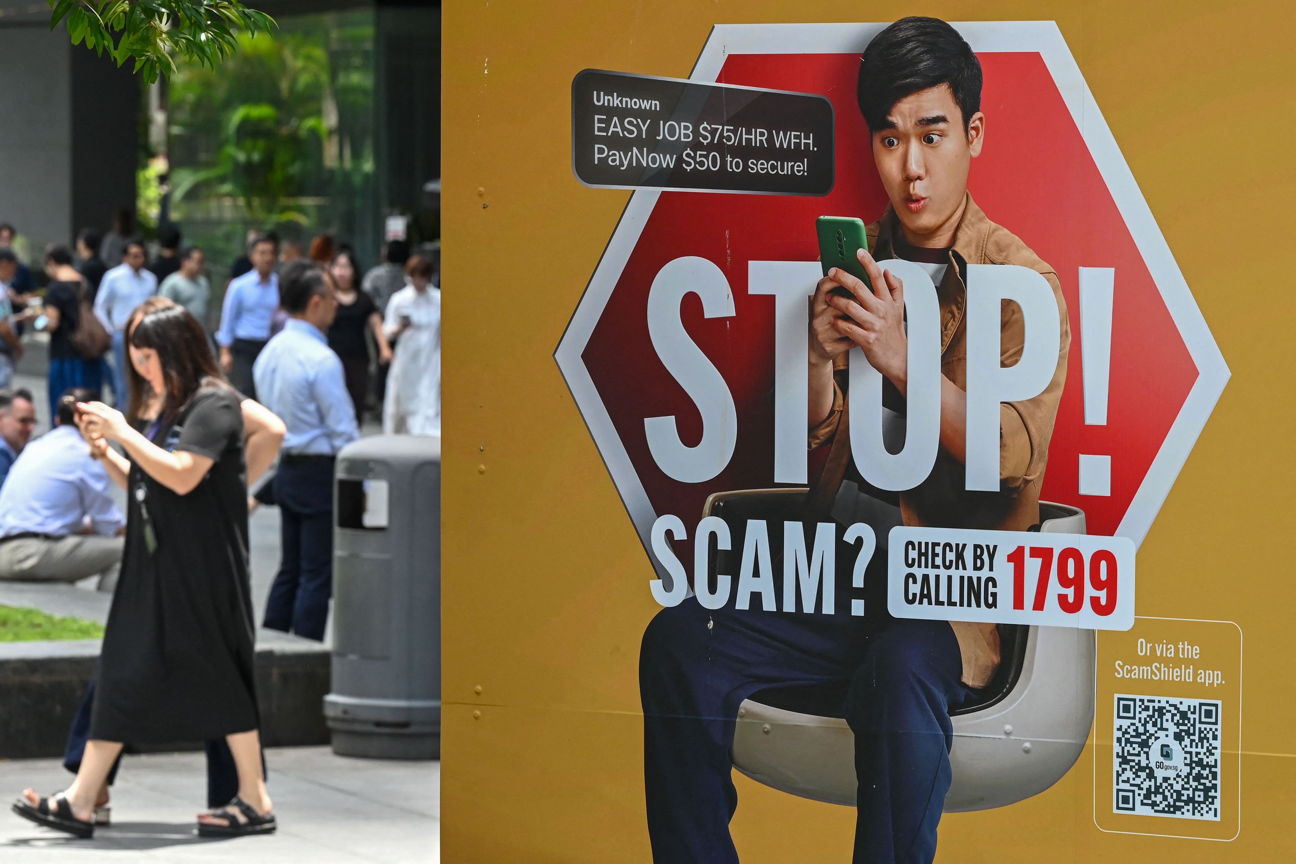 A poster warning of scam threats in Singapore’s Raffles Place district (Photo: Roslan Rahman/AFP)