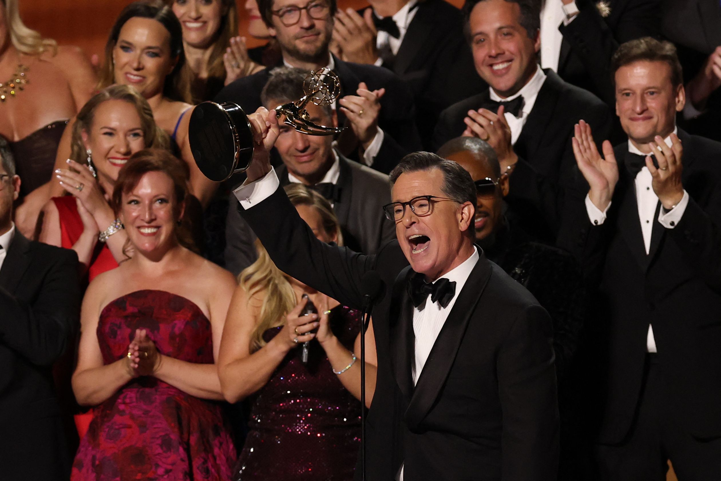 โคลแบต์ (กลาง) ขณะรับรางวัลรายการทอล์กยอดเยี่ยมบนเวที Emmys 2025 (ภาพจาก: Valerie Macon/AFP)