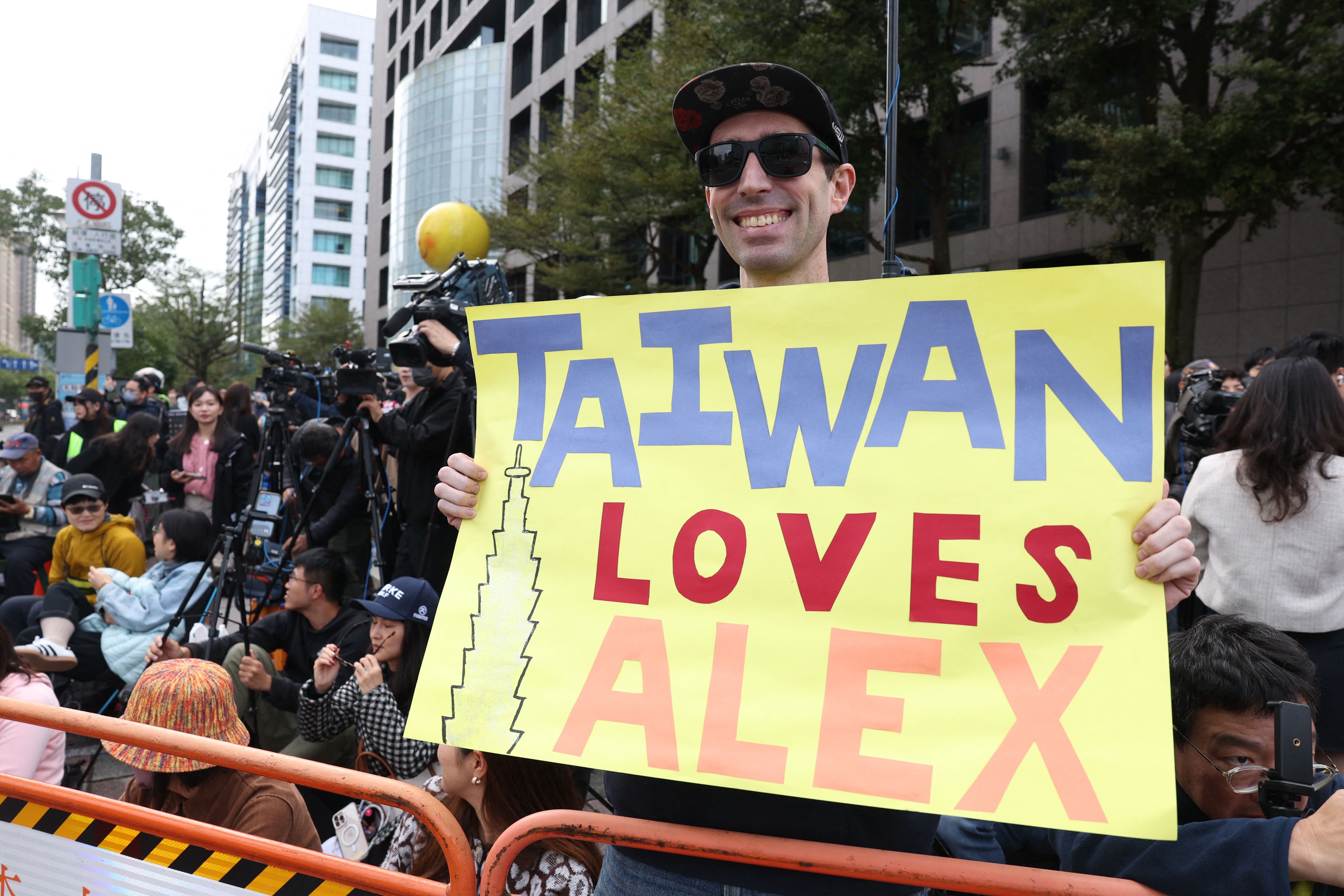 กองเชียร์ของ Alex Honnold ที่หน้าตึก Taipei 101 (ภาพ: I-Hwa Cheng/AFP)