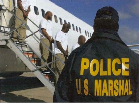 ผู้ต้องหาขณะกำลังลงจากเครื่องบิน JPATS ดูแลโดย U.S. Marshals Service