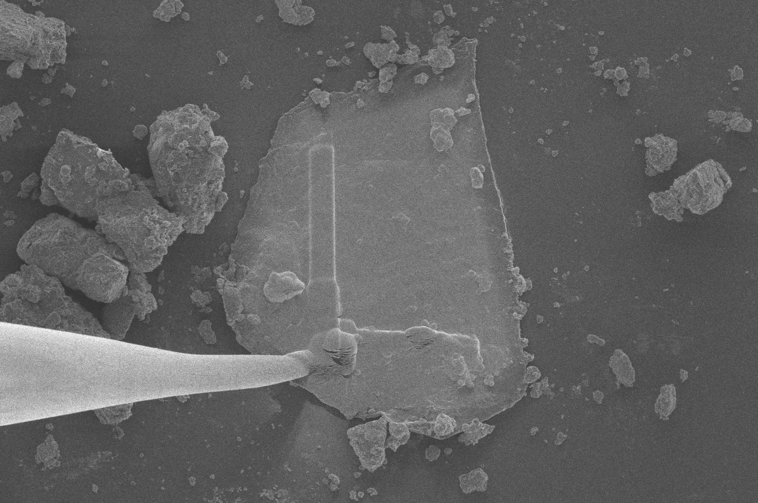 ภาพของเข็มกล้องจุลทรรศน์กำลังขยับเศษชิ้นส่วนของตัวอย่างหินดาวเคราะห์น้อยเบนนู ภาพจาก NASA