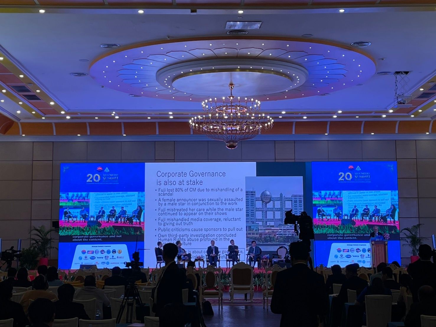 Ogawa (ด้านขวา บนโพเดียม) กำลังบรรยายในงาน 20th Asia Media Summit ที่เมืองเสียมราฐ กัมพูชา