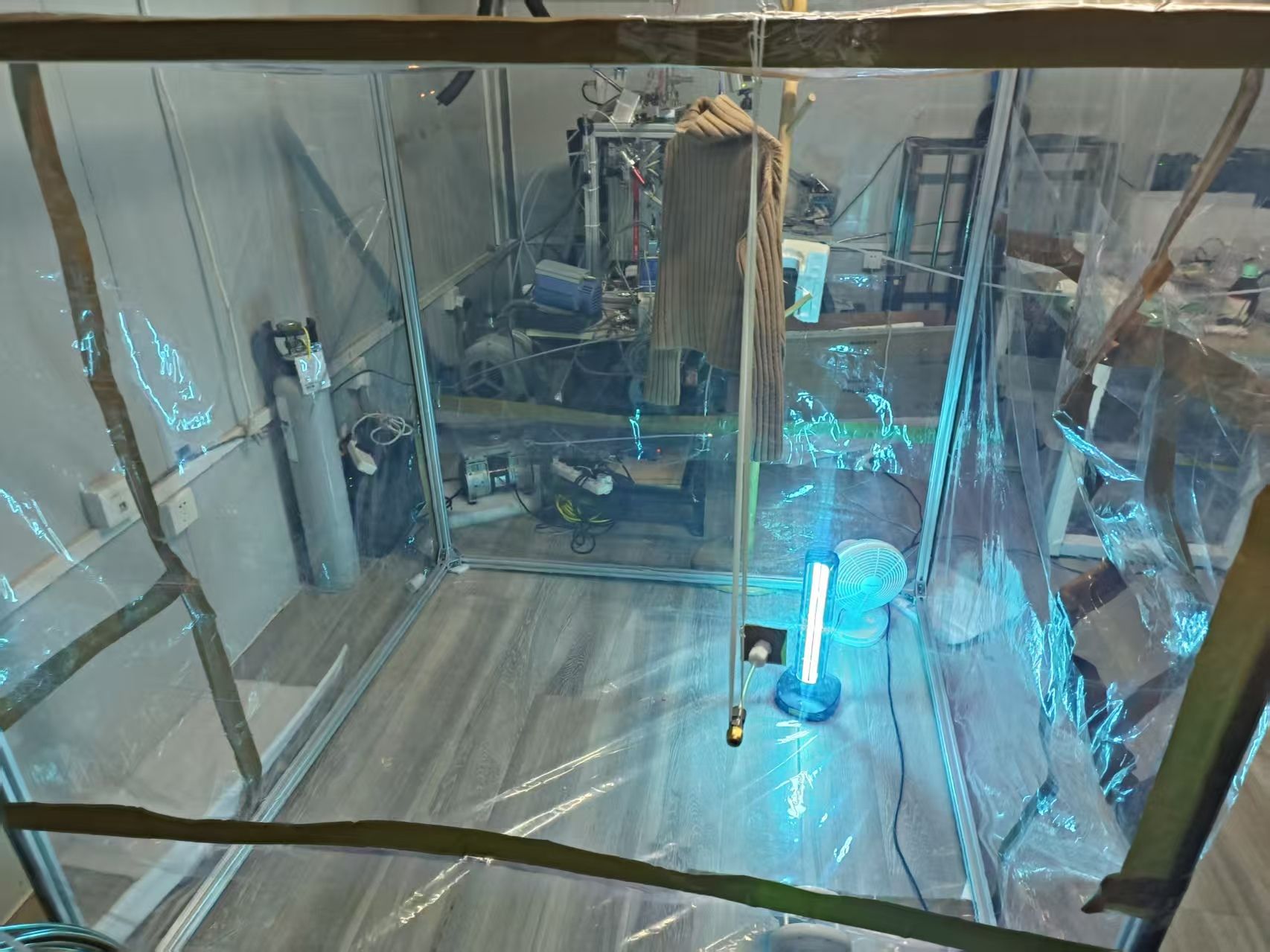 เสื้อสเวตเตอร์ขนสัตว์ที่สัมผัสกับควันบุหรี่มือสามถูกแขวนไว้ภายในห้องฟิล์มเทฟลอนที่สร้างขึ้นเป็นพิเศษ เพื่อใช้ในการทดลองออกซิเดชันโอโซนแบบควบคุม ภาพจาก Yang Liu